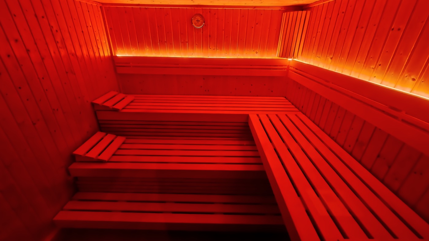 Dieselbe Sauna bei rotem Farblicht — die Beleuchtung ist frei einstellbar