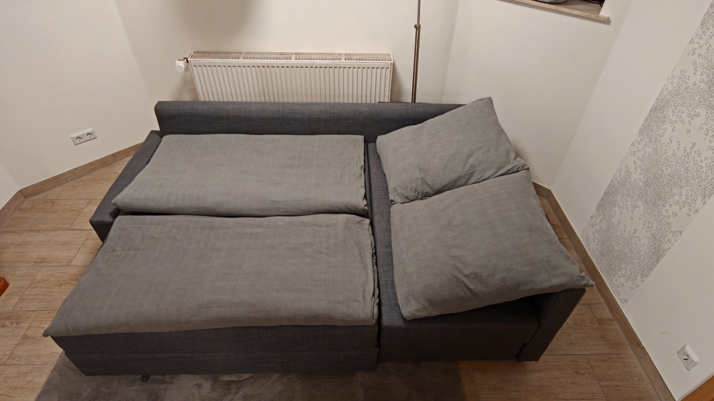 Das ausgeklappte Schlafsofa im Wohnbereich, bezogen für zwei Personen