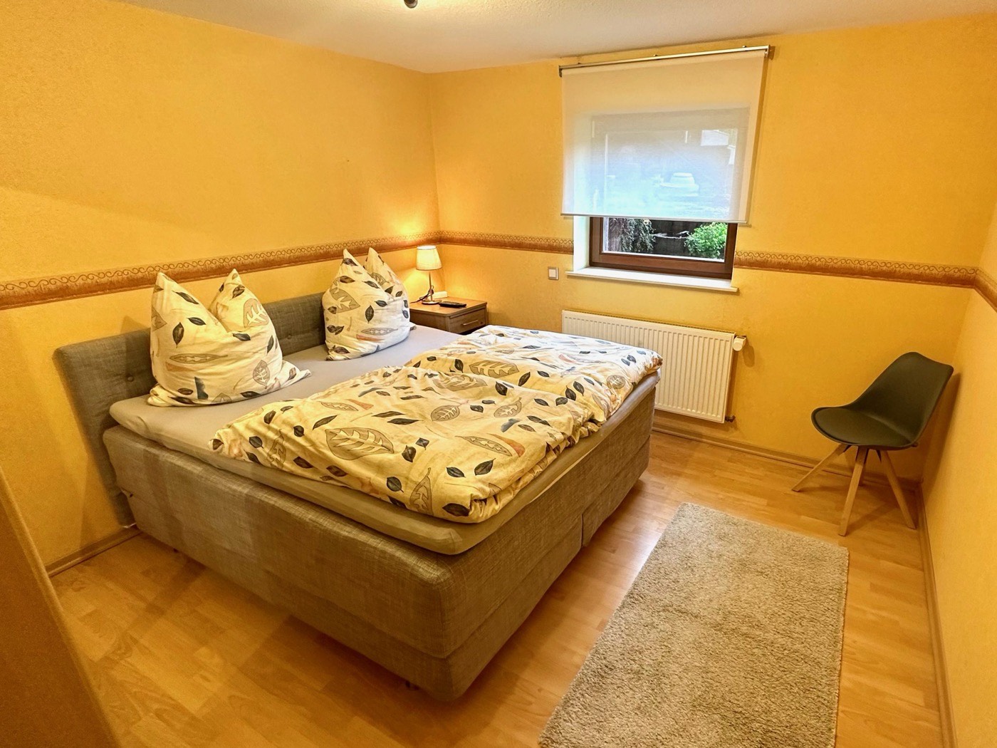 Schlafzimmer 2 mit großem Bett, Nachttisch und Fenster